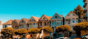 San Francisco 7 gleich gebaute häuse rin unterschiedlichen Farben nebeneinander an einer Straße mit Steigung. Versinnbildlichen: alles unter einem Dach