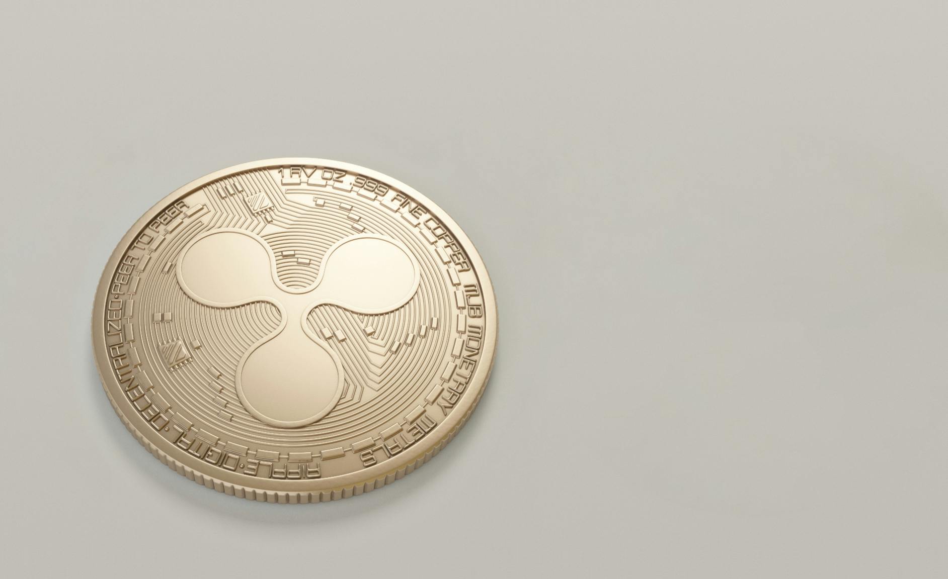 Ripple Coin, drei kreise geprägt auf eine Münze, die Kreise sind in gleichem abstand zueinander und verbunden durch schmale stege von jedem Kreis einer zur Mitte hin, alles ist abgerundet, keine ecken.